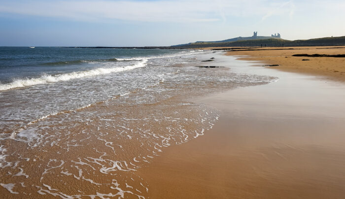 Looking across beach to Dunstanburgh Castle