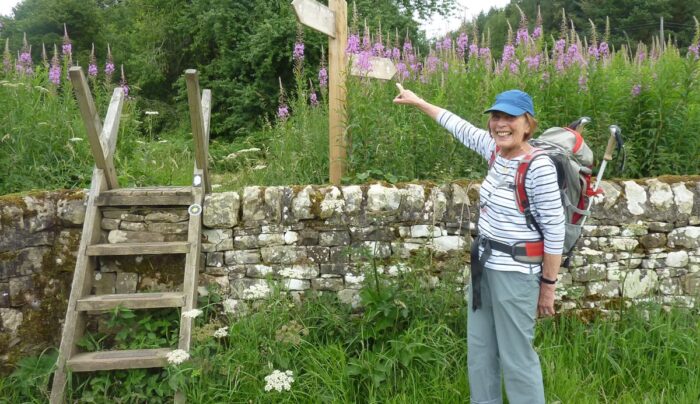 An Absolute Escapes client with a Hadrian's Wall Path waymarker (credit - Andrew Smith)