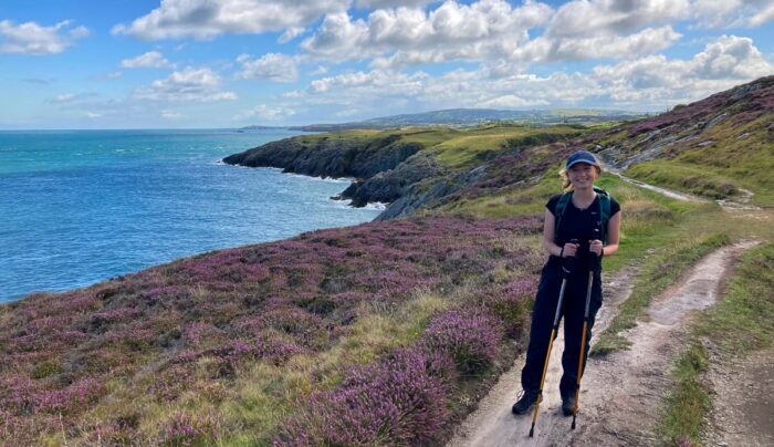 Daisy from the Absolute Escapes team walking along the coastline near Trwyn Myn